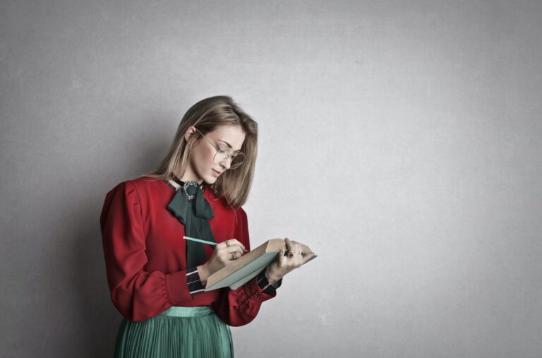 Eine Frau schreibt in ein Notizbuch.