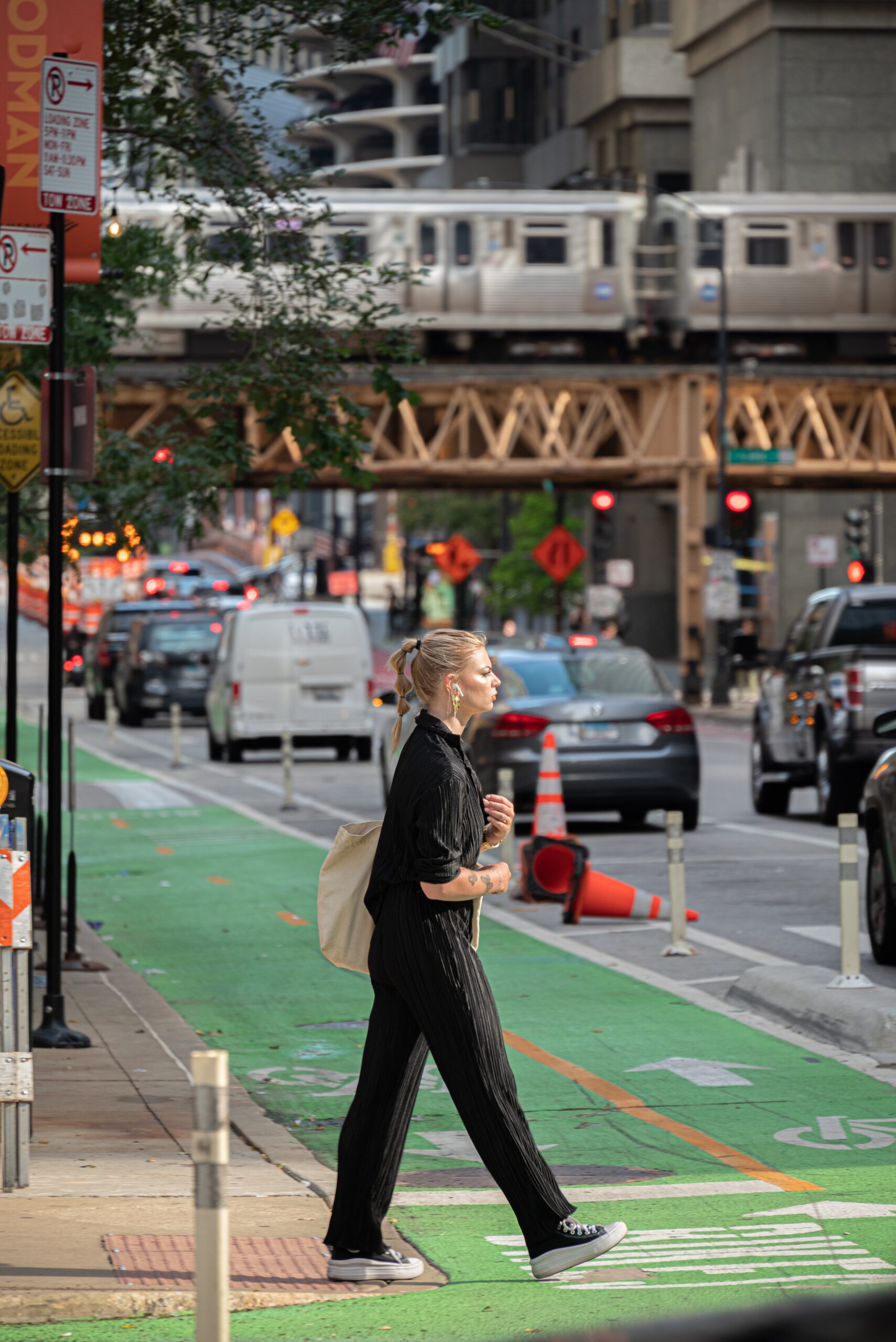 Eine Frau überquert die belebte Straße einer Großstadt.