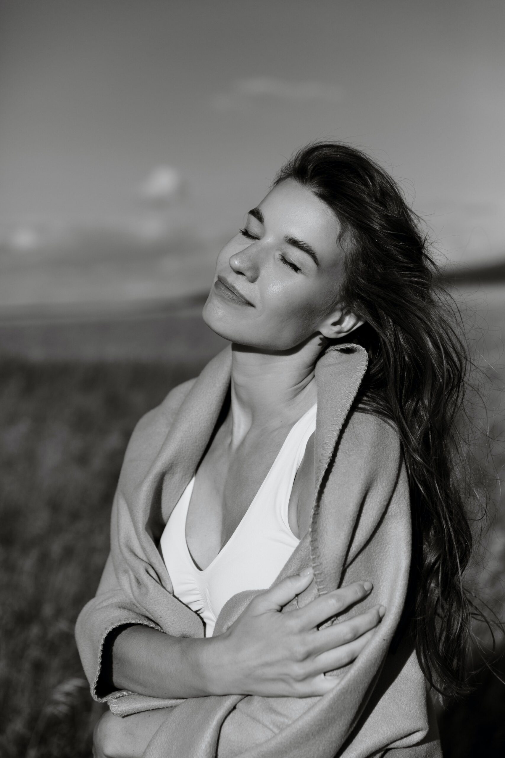 Schwarz-Weiß-Bild einer Frau, die zufrieden die Augen geschlossen hält.