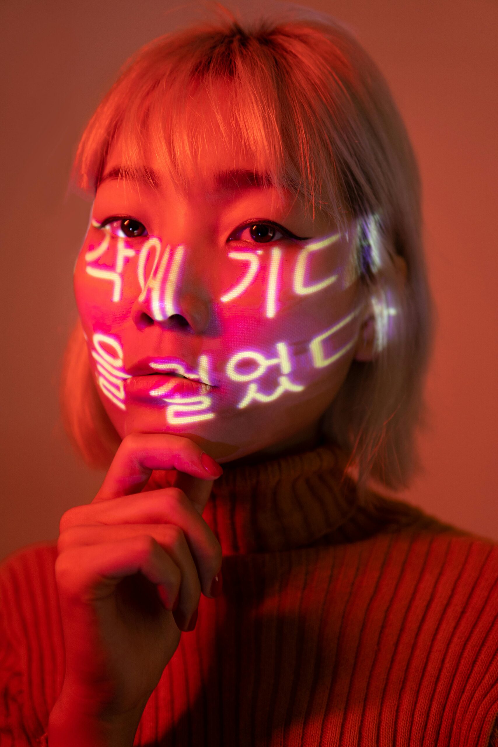 Eine asiatische Frau mit koreanischen Schriftzeichen auf dem Gesicht.
