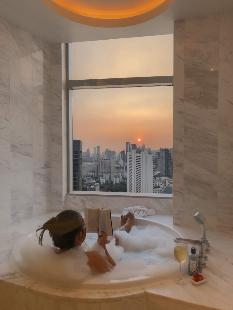 Eine junge Frau liest in der Badewanne.
